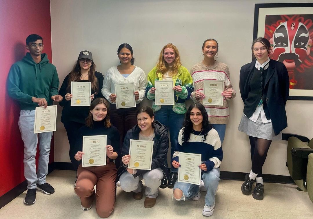 Induction from the Temple University Nu Rho Psi chapter. There are 9 students total, 8 of whom are holding their certificates.