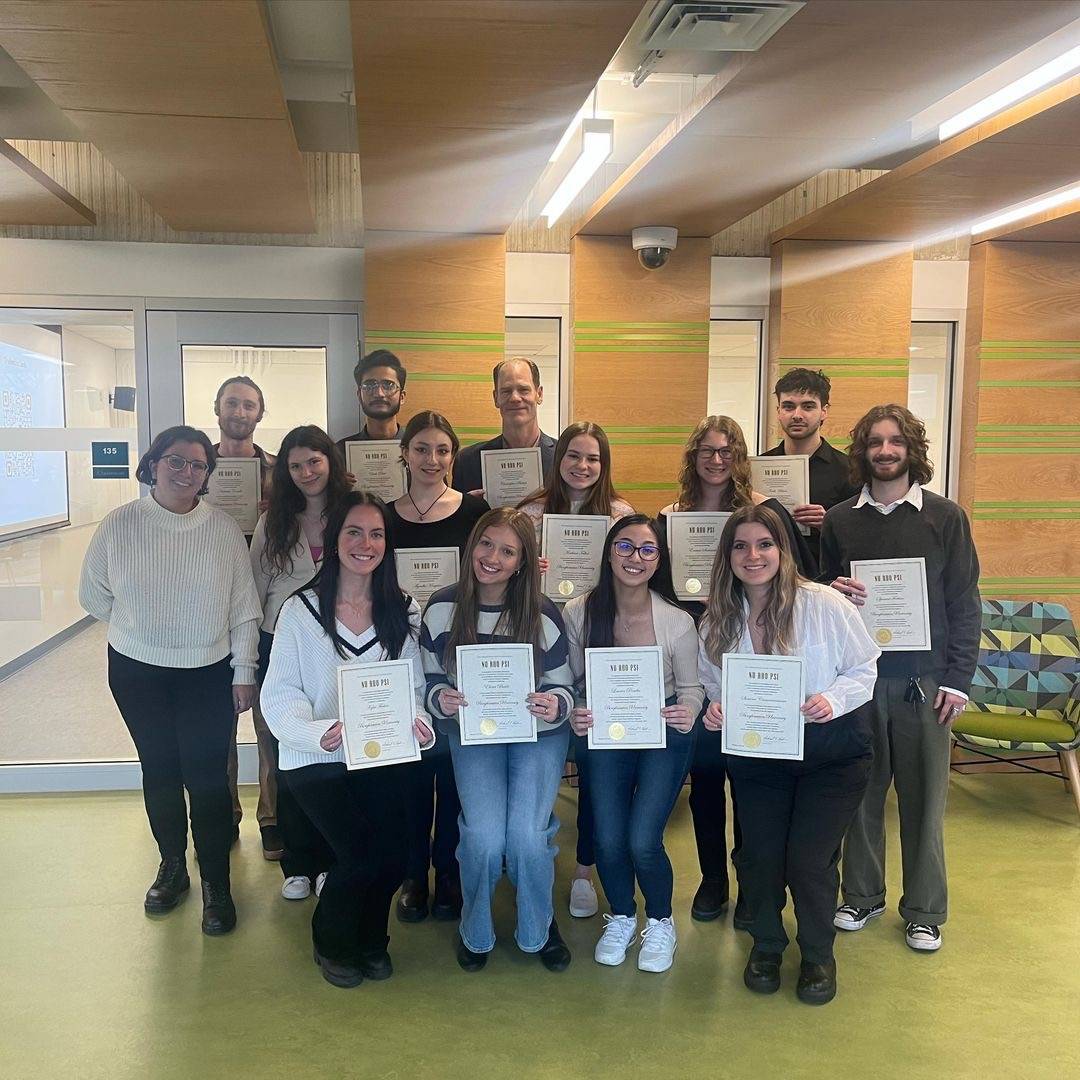 The Binghamton University Spring 2024 newly inducted members. There are three rows of members, with 14 members in total. All of the members in the photo are smiling, and most of them are holding their certificates.